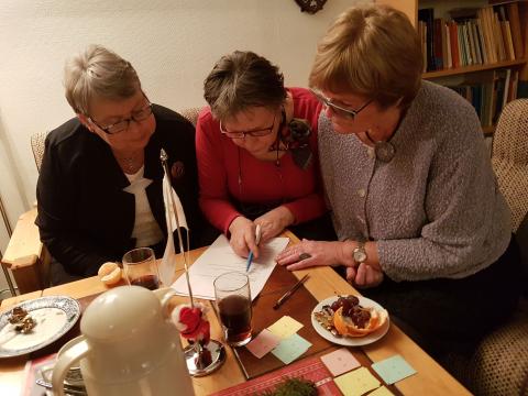 Konsentrert rundt kveldens quiz. Randi Svebakk, Anne Berit Finden og Jorun Sundby