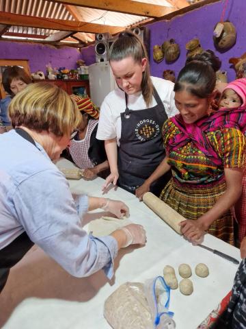 Anna Opheim viser flatbrødbaking til unge Maya-kvinne
