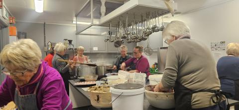 Mange kvinner i sving på kjøkenet