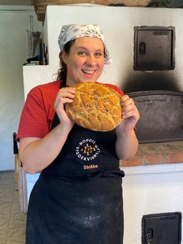 Celine Marie Slettebø representerer alle våre 11.000 bygdekvinner. Celine er en dyktig baker og koser seg sammen med de andre bygdekvinnene i Stokke når de baker i sin egen vedfyrte ovn. I sommer viste hun oss i en matvideo hvordan lage brød i vedfyrt ovn. Foto: Helle Cecilie Berger.