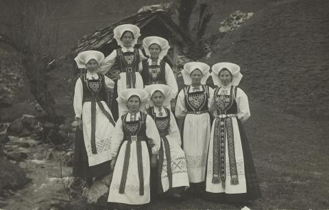 Sju kvinner i hardangerbunad. Foto: Nasjonalbibliotekets bildesamling.