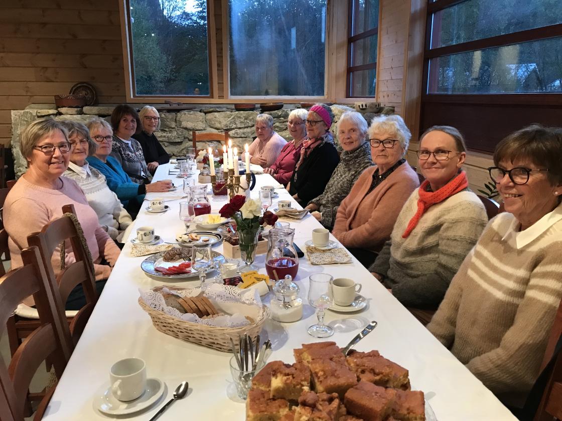 12 blide damer samla rundt bordet.