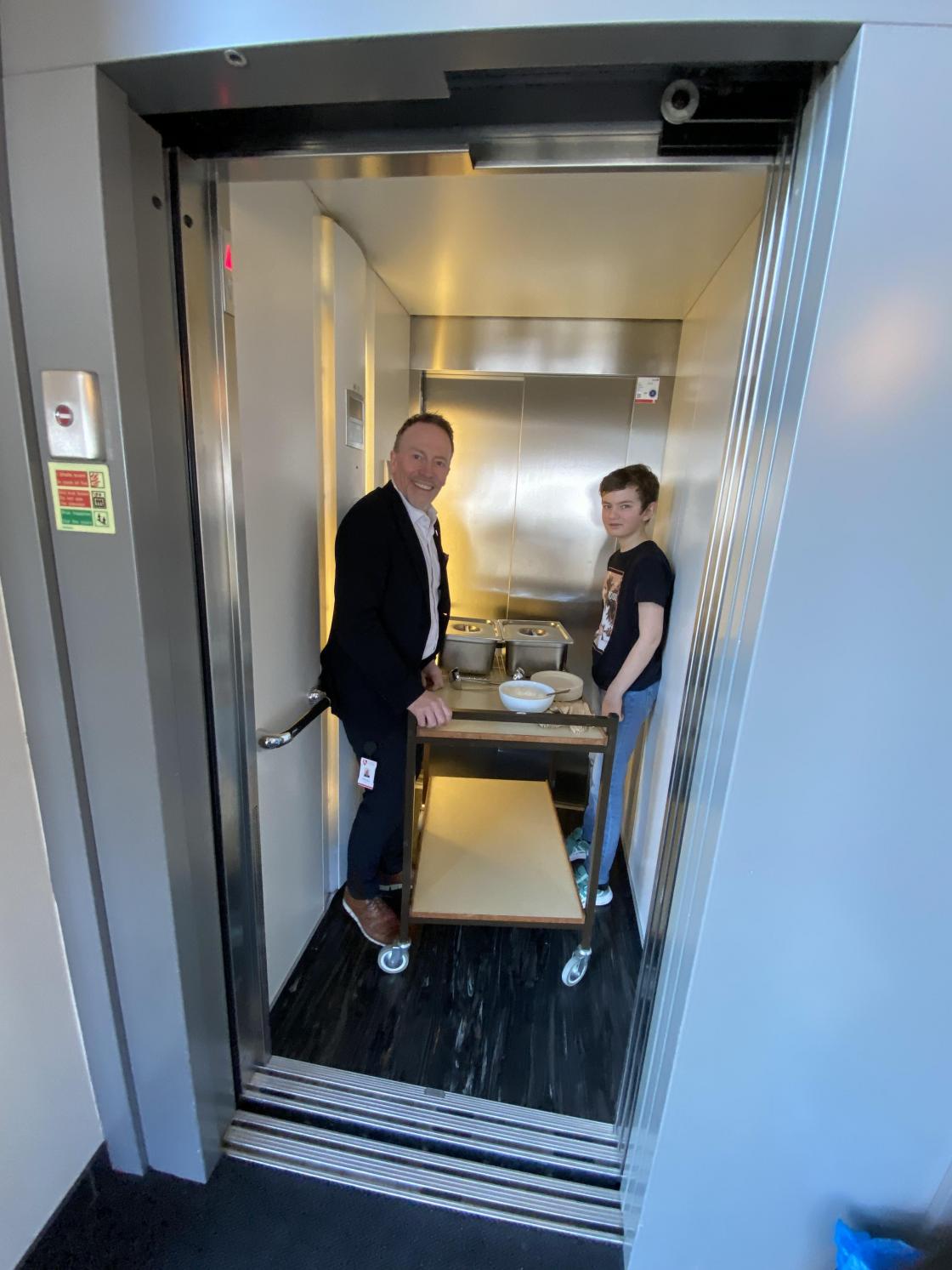 Ordfører Kai Ove Berg på vei til å servere mat i klasserom med elevrådslederen.