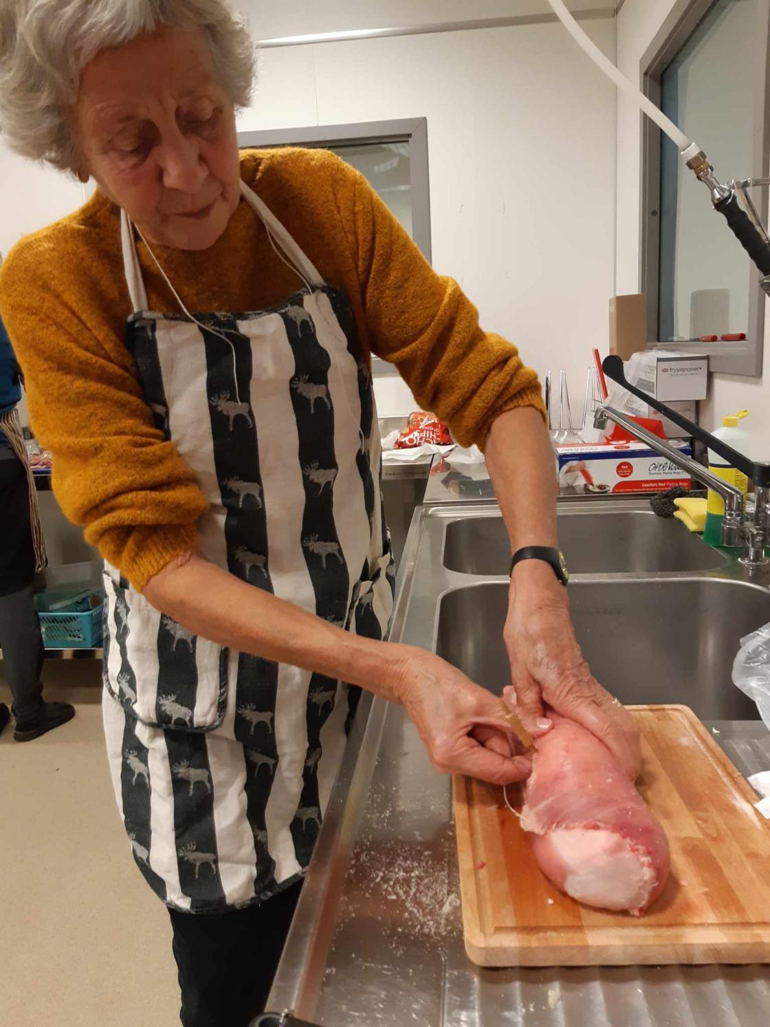 Kvinne med kjøttrull som snart er ferdig rullet