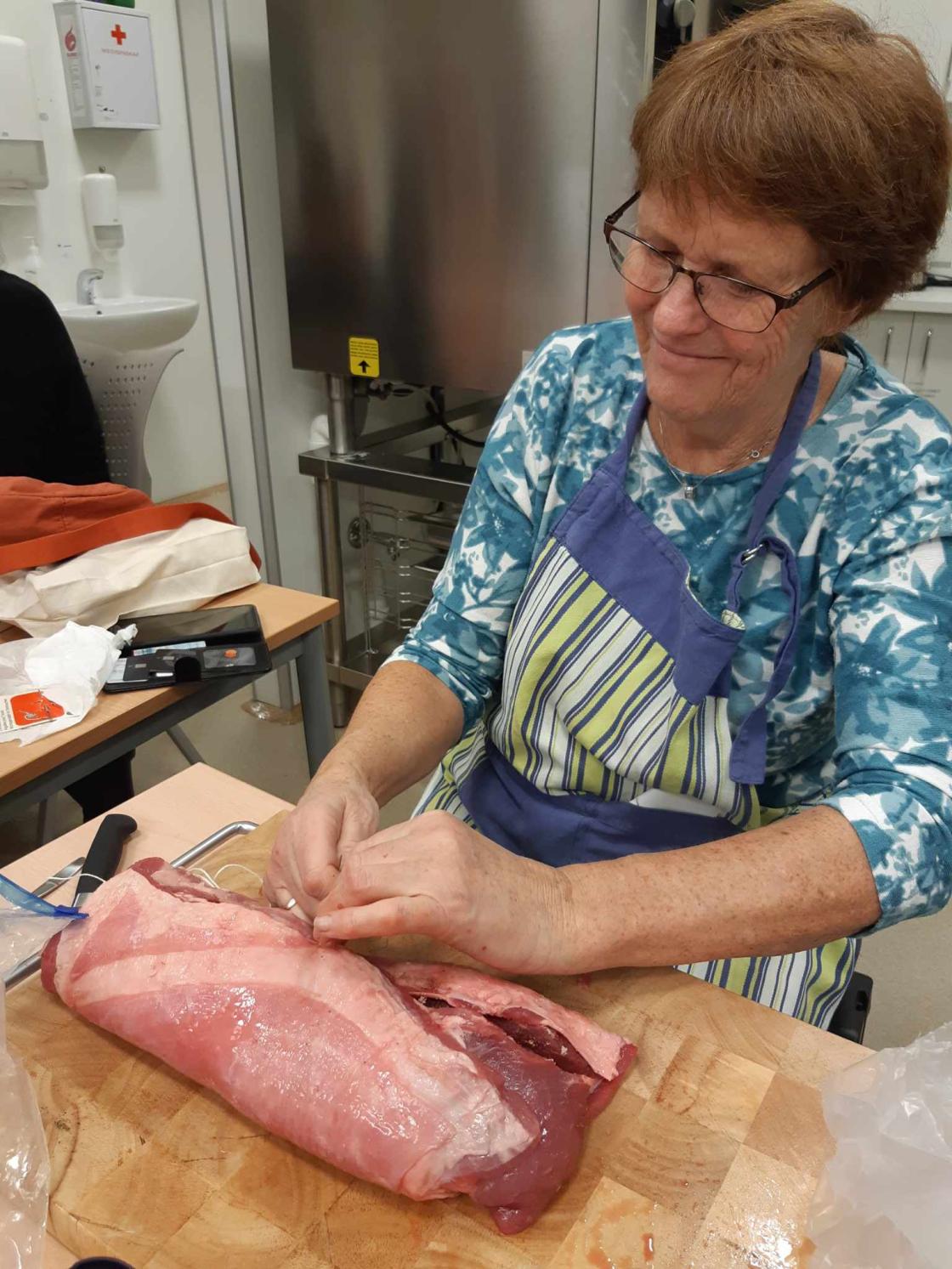 Kvinne med kjøttrull som snart er ferdig rullet