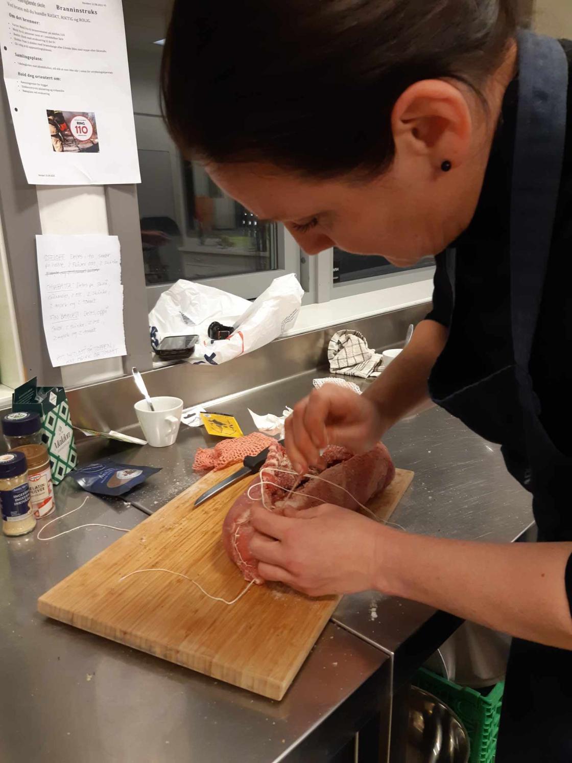 Kvinne med kjøttrull som snart er ferdig rullet