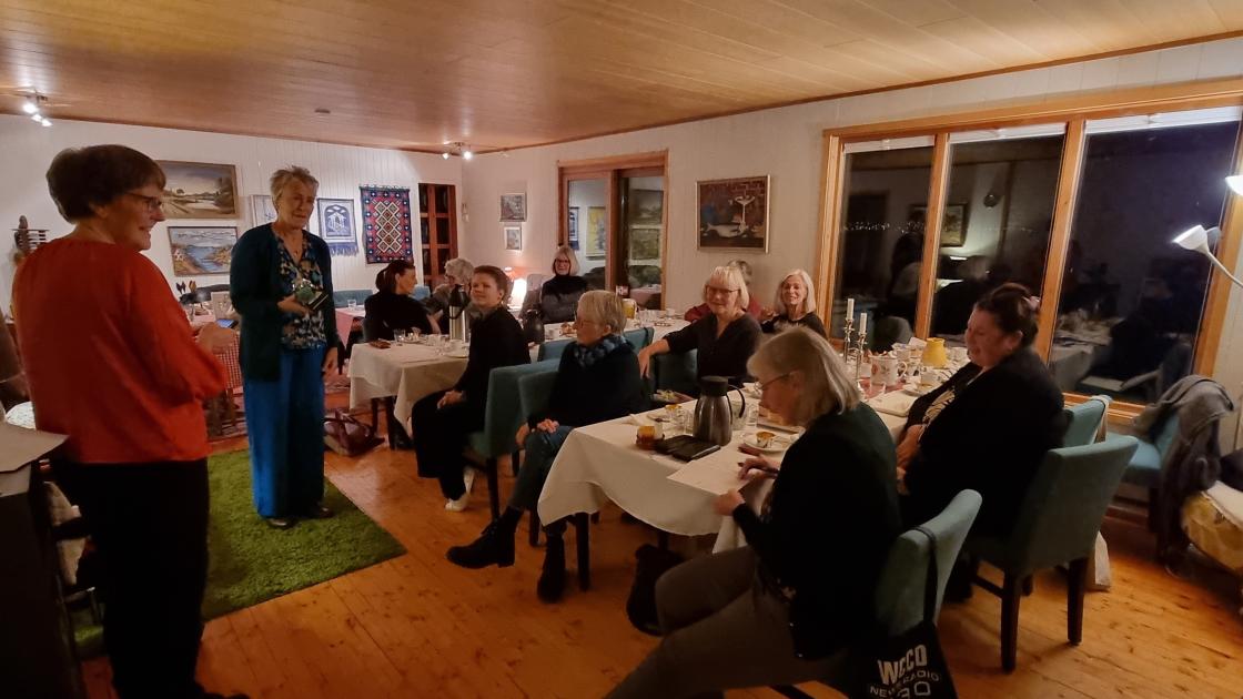 Kvinner som sitter langs to langbord mens to står og deler ut loddpremier