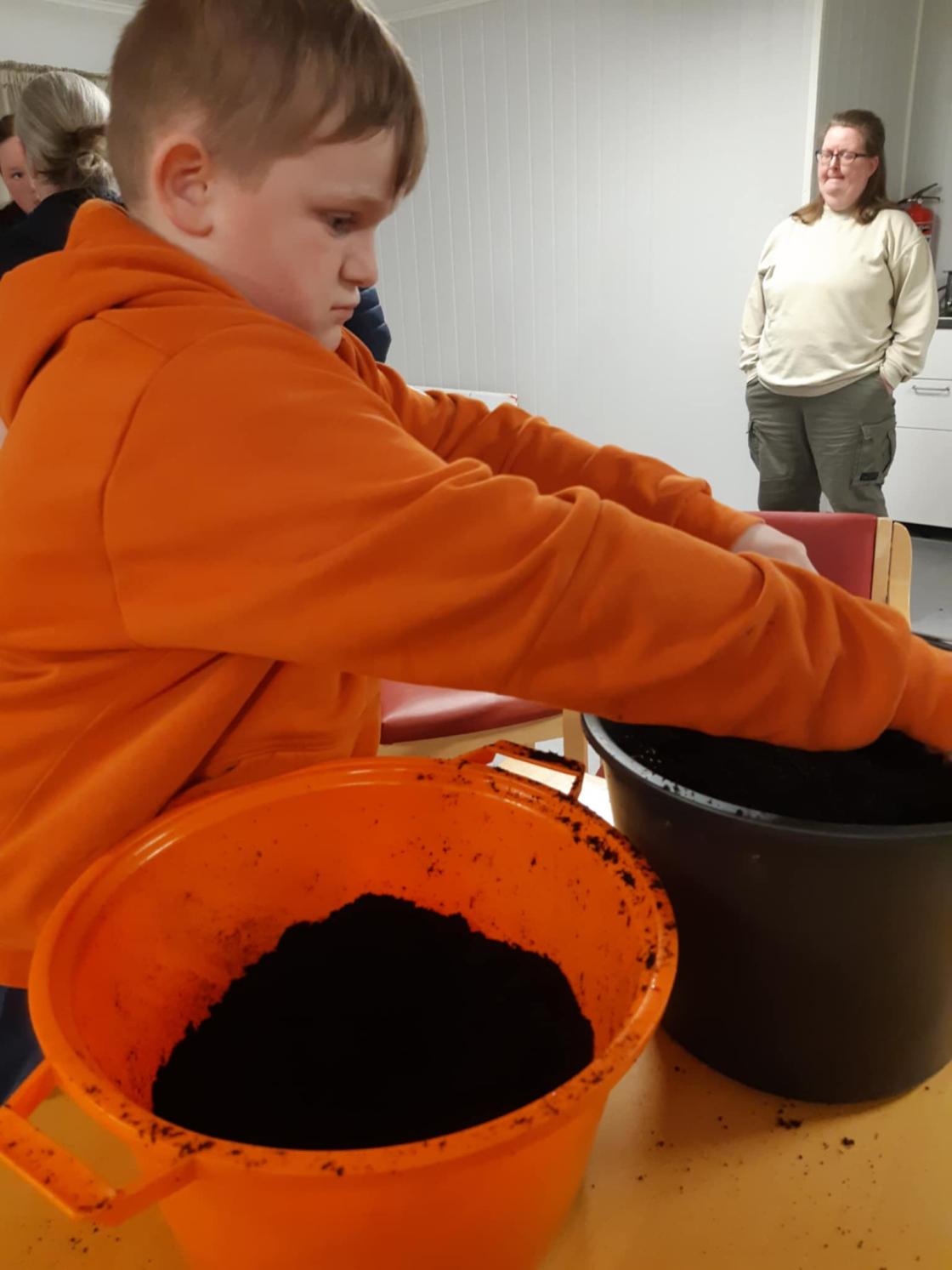 Barn har jord i store potter