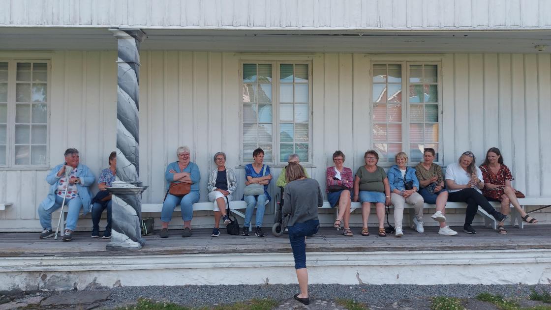 Damene sitter pent på rad. Foto AK