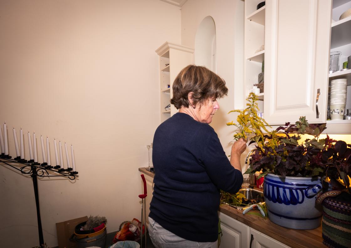 Wenche setter sammen blomster for å pynte kirken