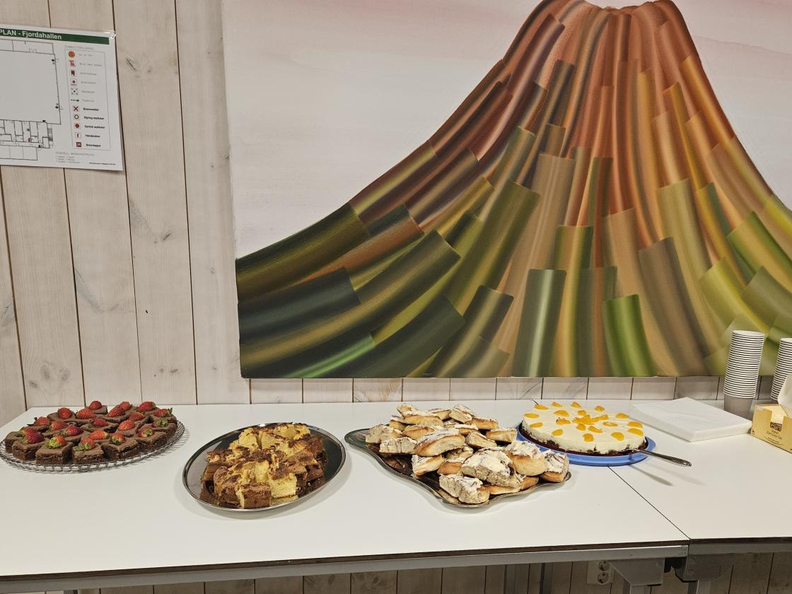 Kaker på eit bord framfor eit maleri