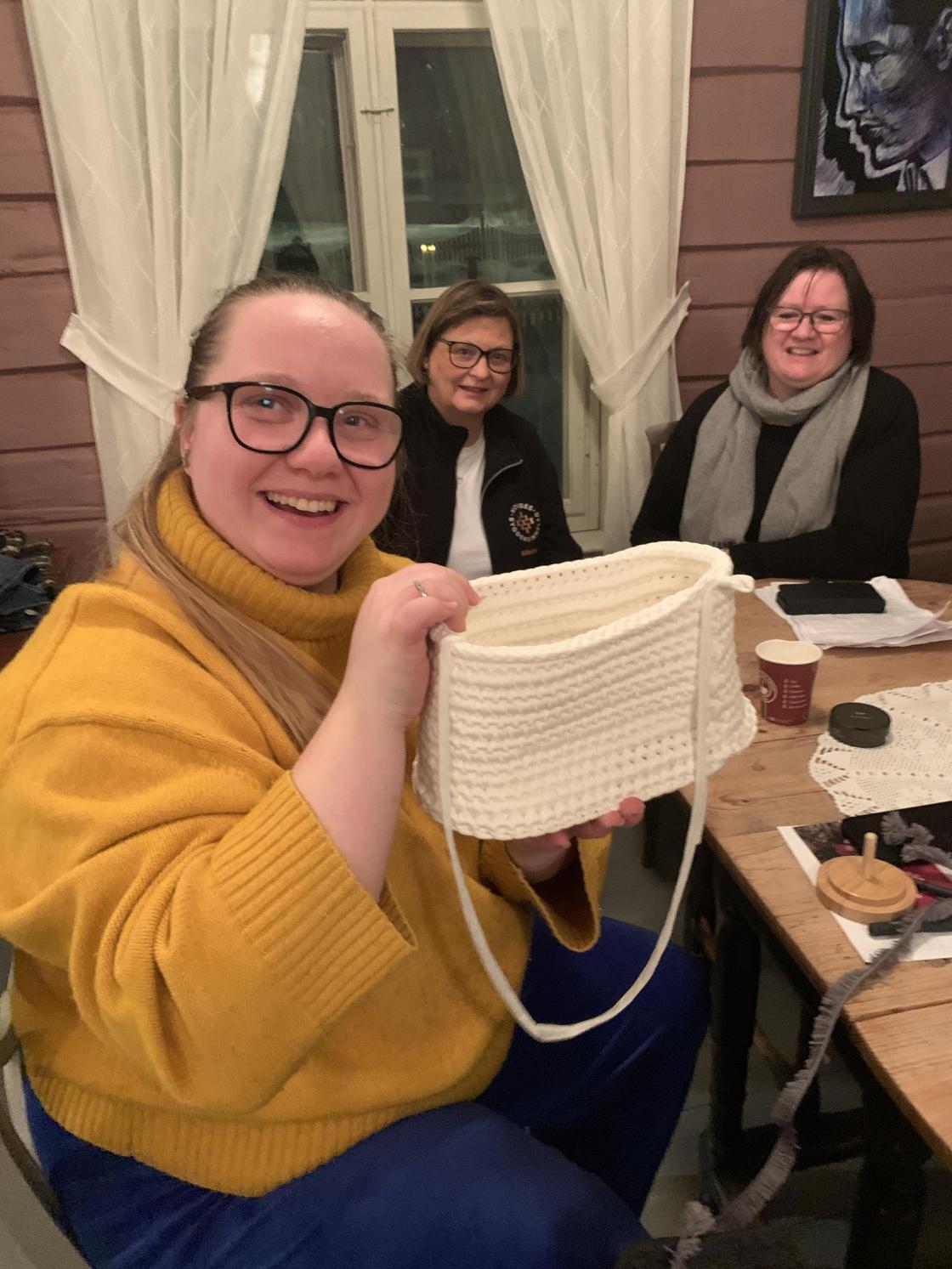 Thea Ulriksen Siegwarth viser blidt fram ei veske hun har heklet.