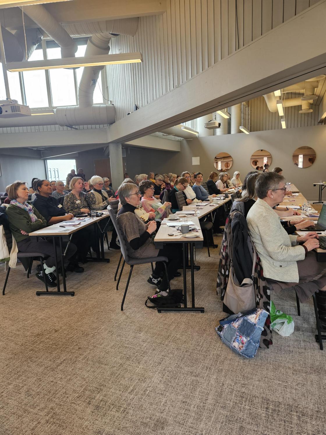 Møterom med deltakarar ved bord