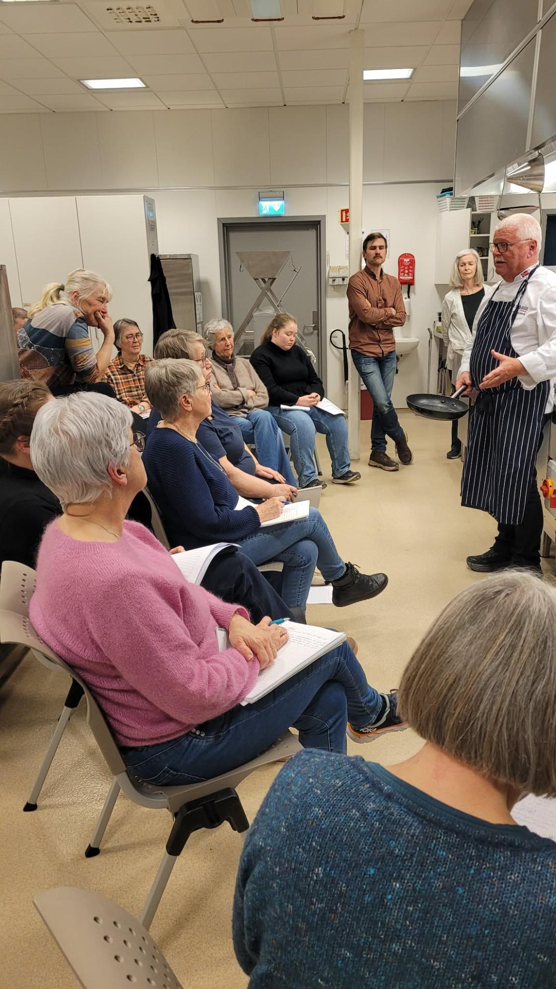 Gruppe kursdeltagere sitter og lytter