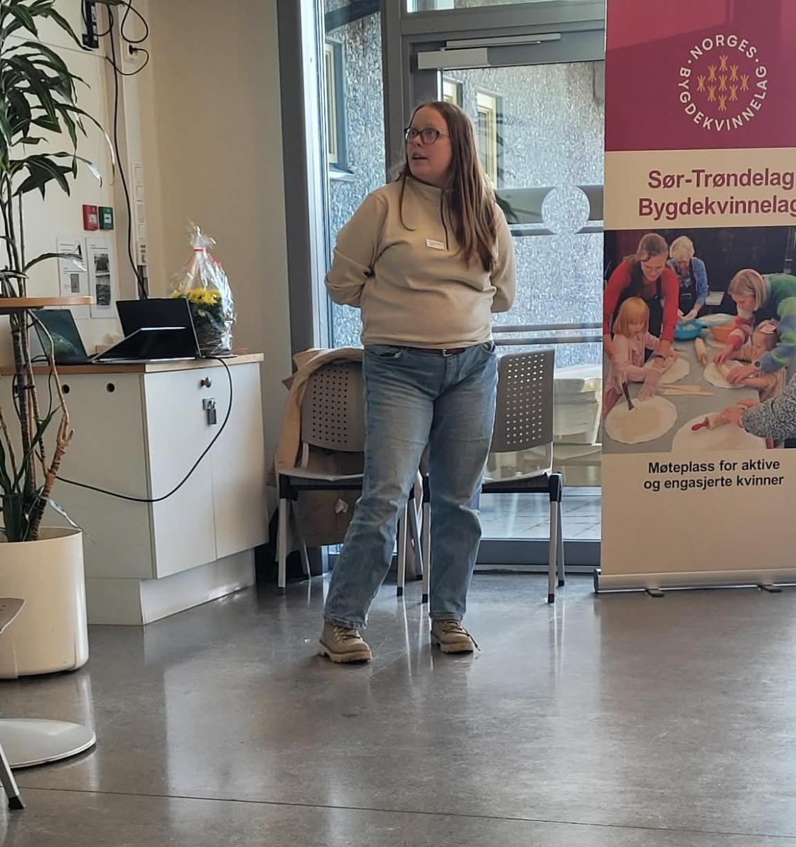 Kvinne står og presenterer sitt lags aktiviteter