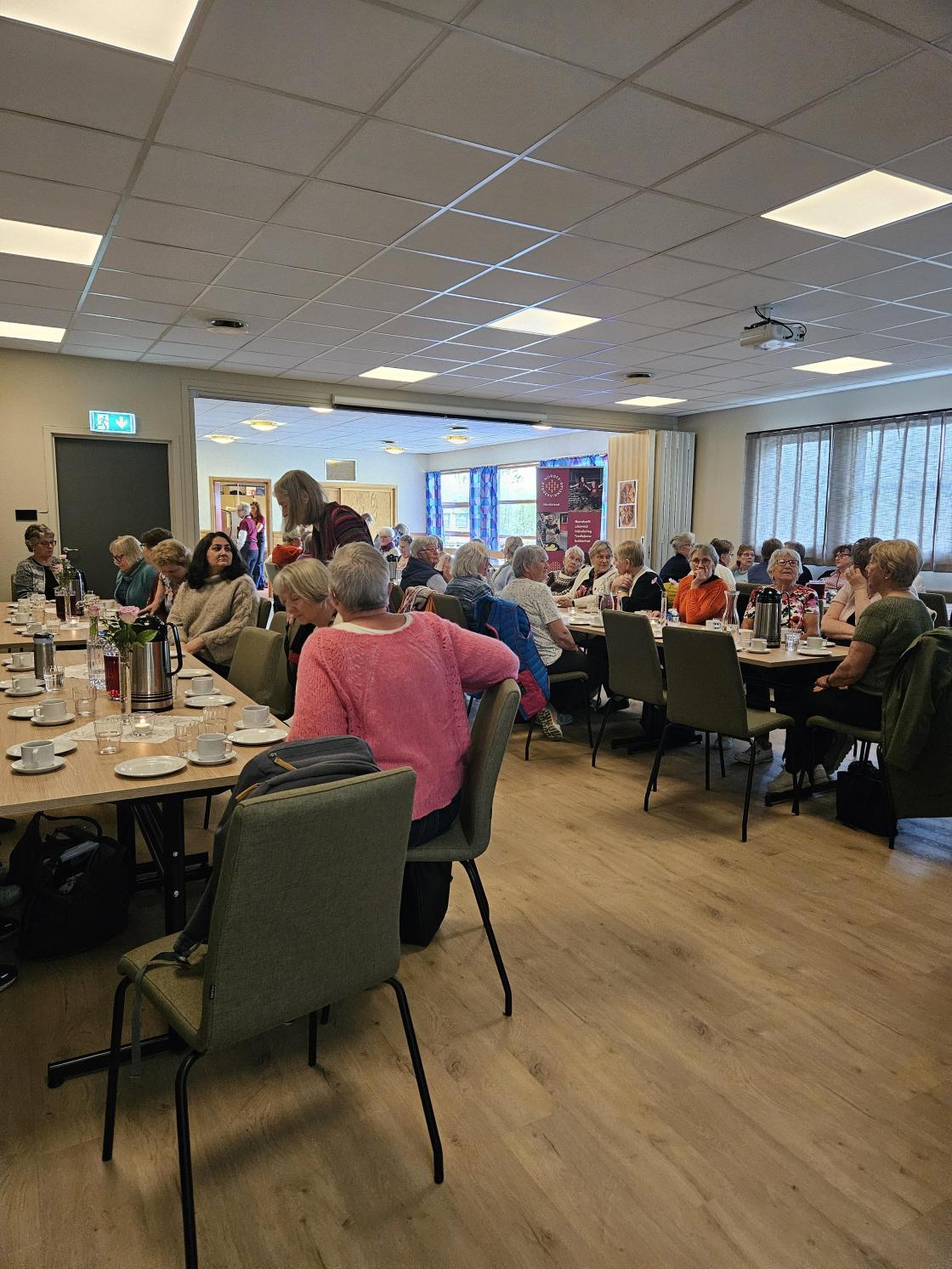 Kvinner rundt bord i festsal