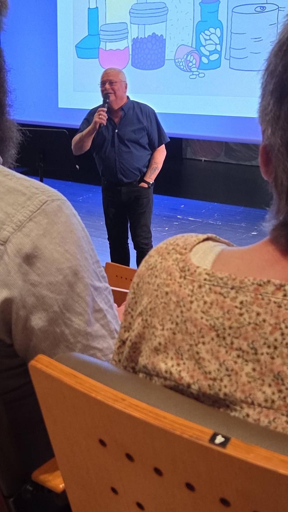 mann på scene med slides bak