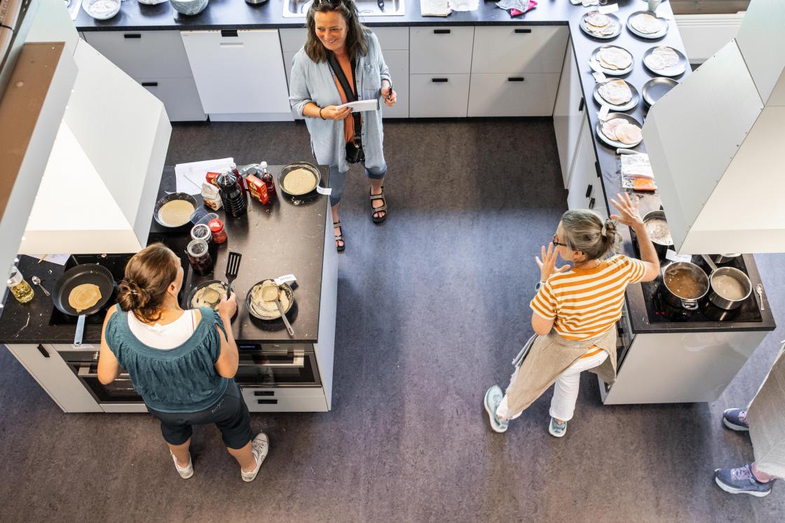 Ingrid Gardseth (til v.) og Cesilie Aurbakken lager matretter med bygg, mens de blir intervjuet av Nationens Siri Juell Rasmussen. Foto: Øyvind Strand Endal.