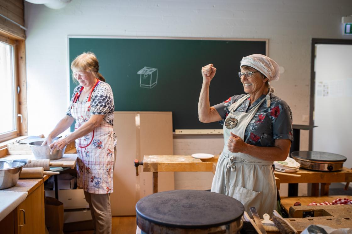 Bygdekvinnelagets Ingebjørg Dybdal (fra venstre) og Marie Skjellerud sto for baking og testing av potetlomper og flatbrød. Foto: Øyvind Strand Endal.