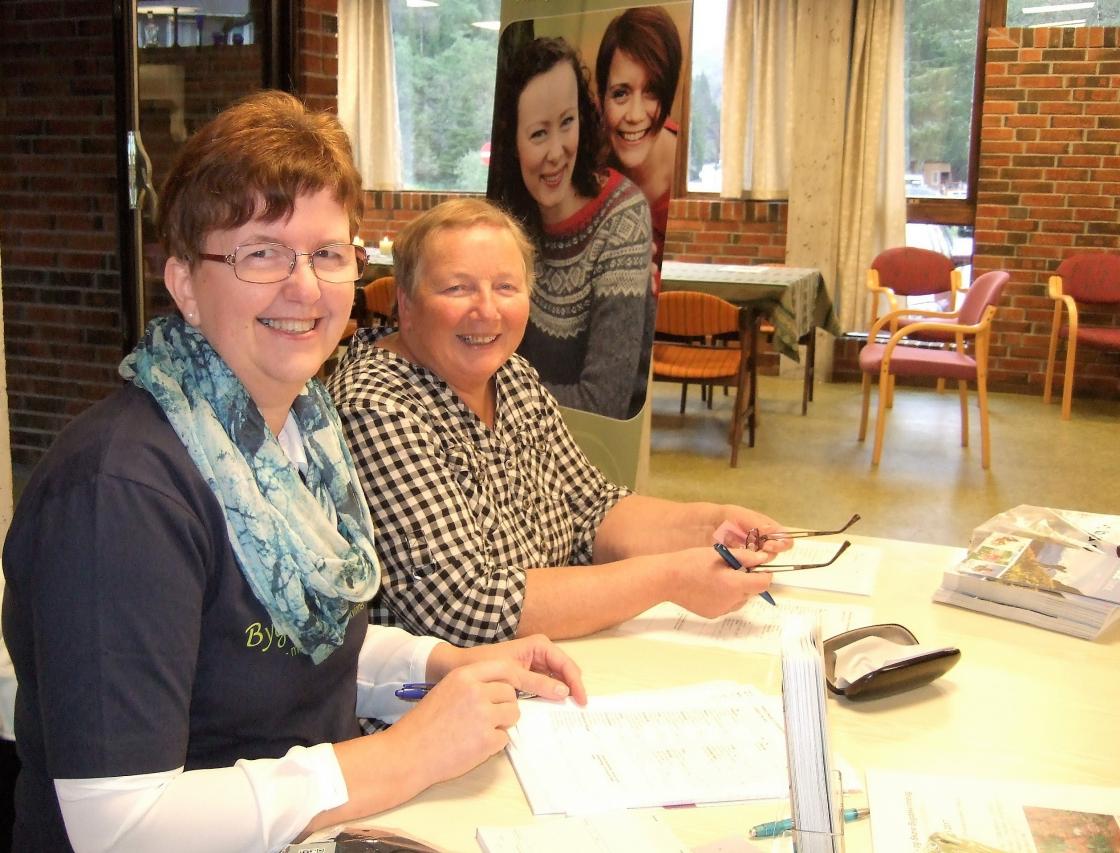 To blide damer selger bøker og t-skjorter. Foto: Bjørg Strømme.