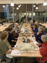 Kvinner samlet rundt langbord for leverposteismaking